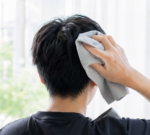 頭の汗をタオルで拭く男性