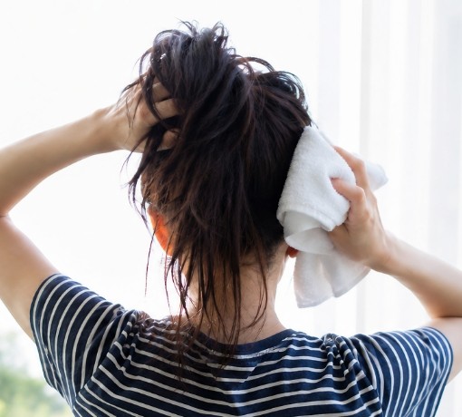 髪をタオルで拭く女性
